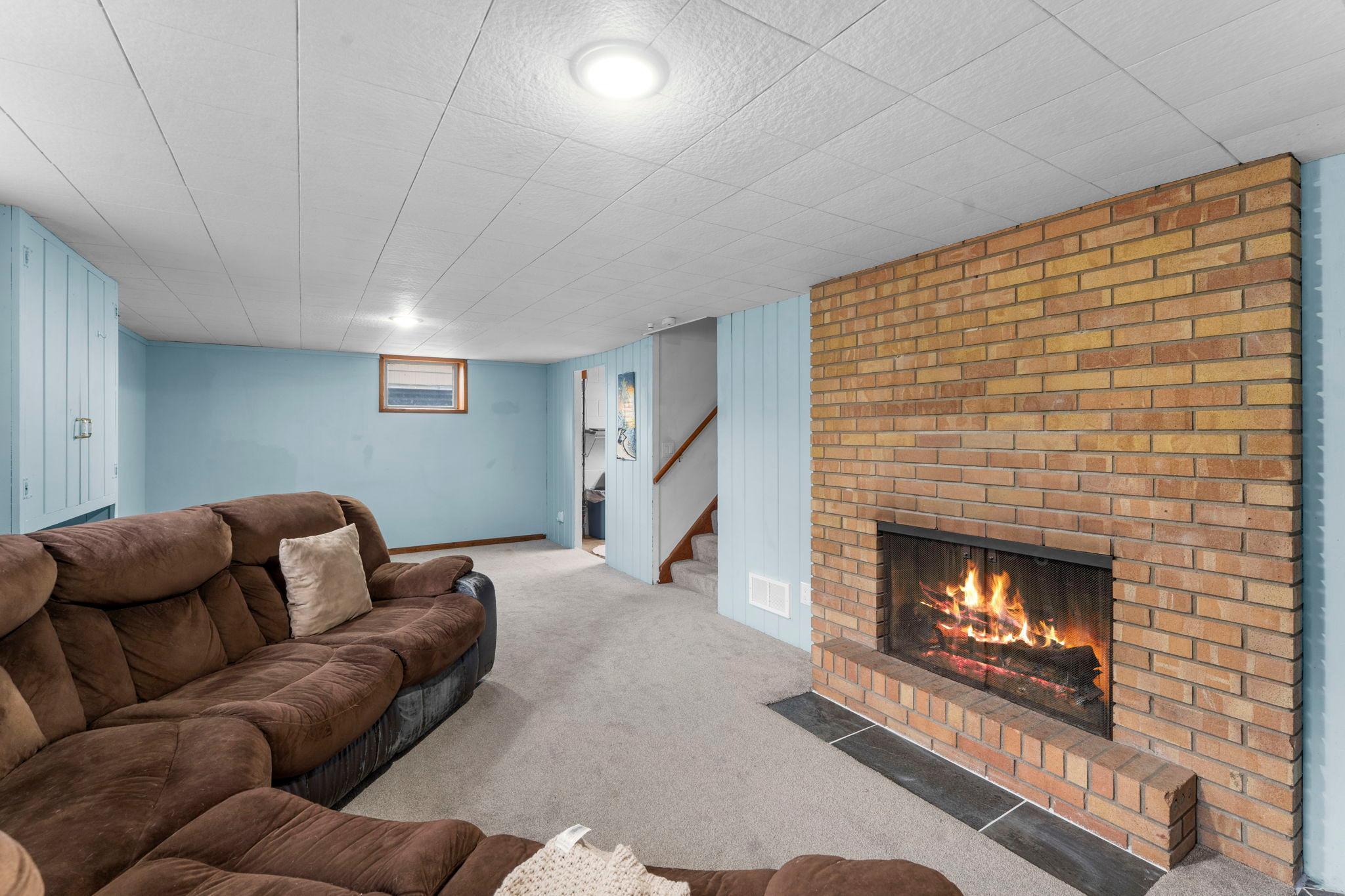 The lower level offers a spacious family room with carpet, a wood-burning stove, and lookout windows.