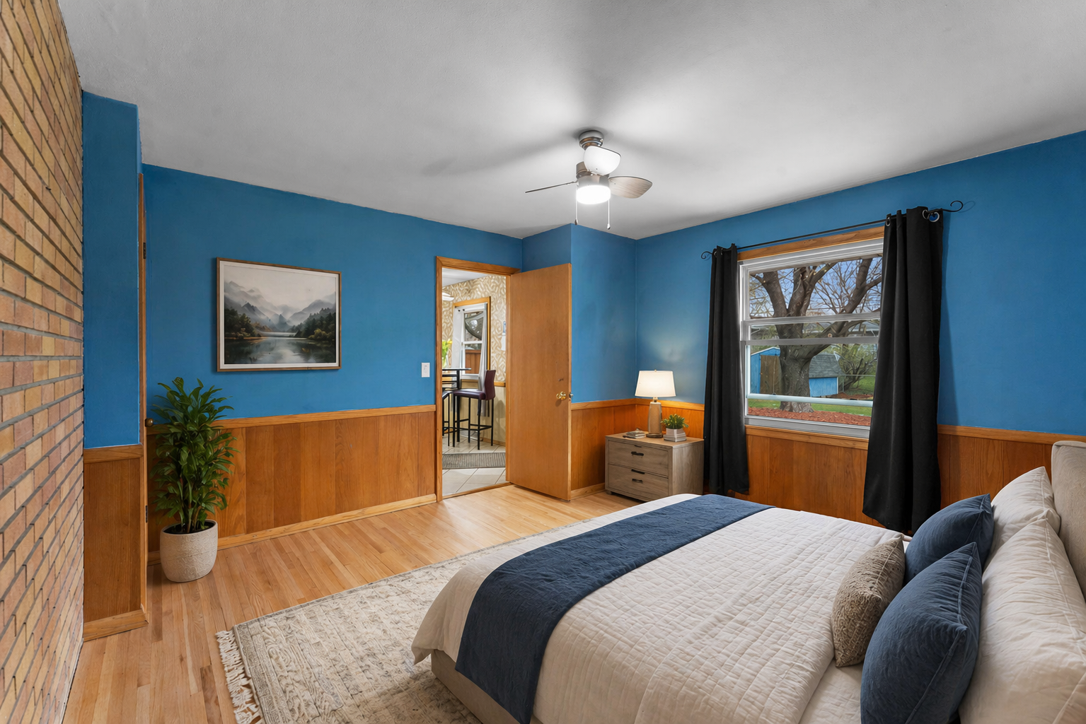 Virtually staged. This is a wonderful flex room. It could be a wonderful bedroom, a dining room or office. This room has so much character and warmth with the brick wall, hardwood floors and wainscoting.