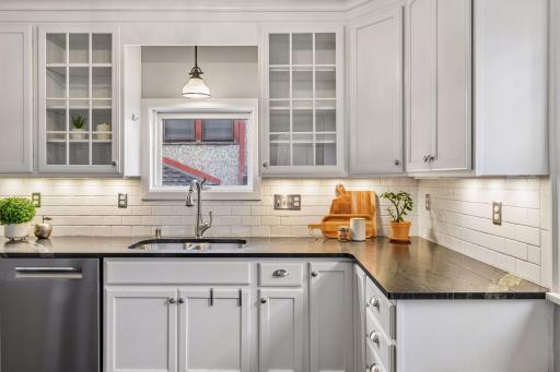 Updated kitchen with crisp white cabinetry and sleek dark countertops