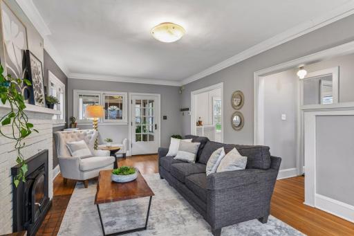 Bright and stylish living area featuring a cozy fireplace, and timeless character throughout