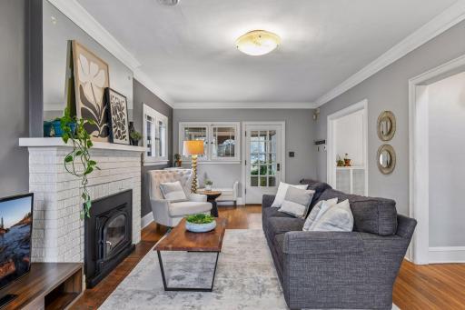 Inviting living room with hardwood floors, classic fireplace, and abundant natural light creating a warm, welcoming space