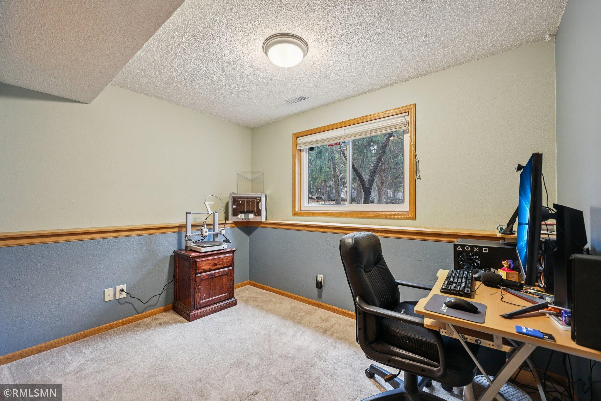 Bedroom 3 is currently used as an office, with views of the backyard