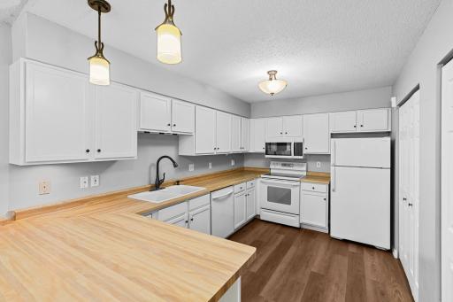 The kitchen with a lot of storage and new flooring.