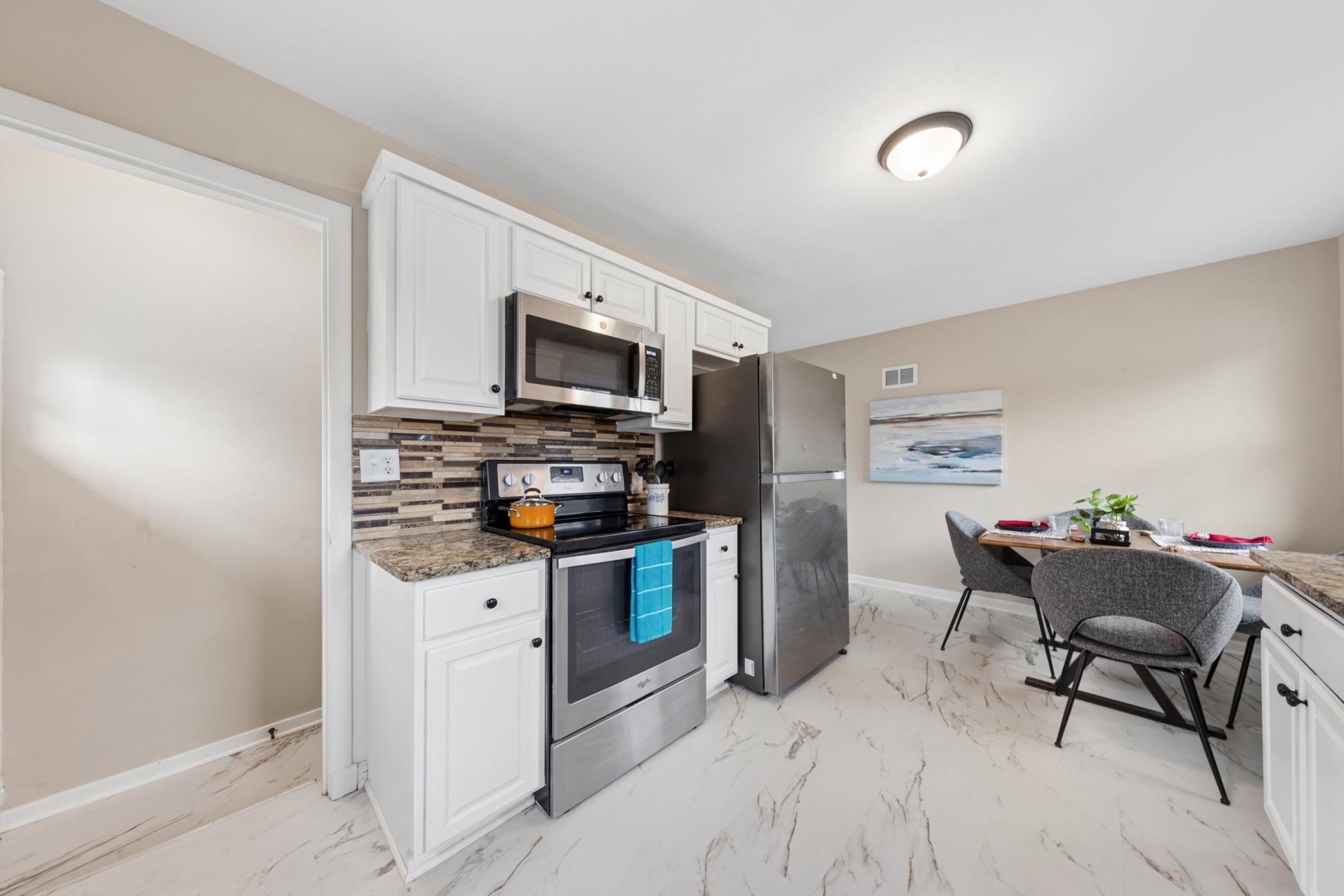 Functional kitchen layout with ample cabinet space, updated finishes, and adjacent dining area.