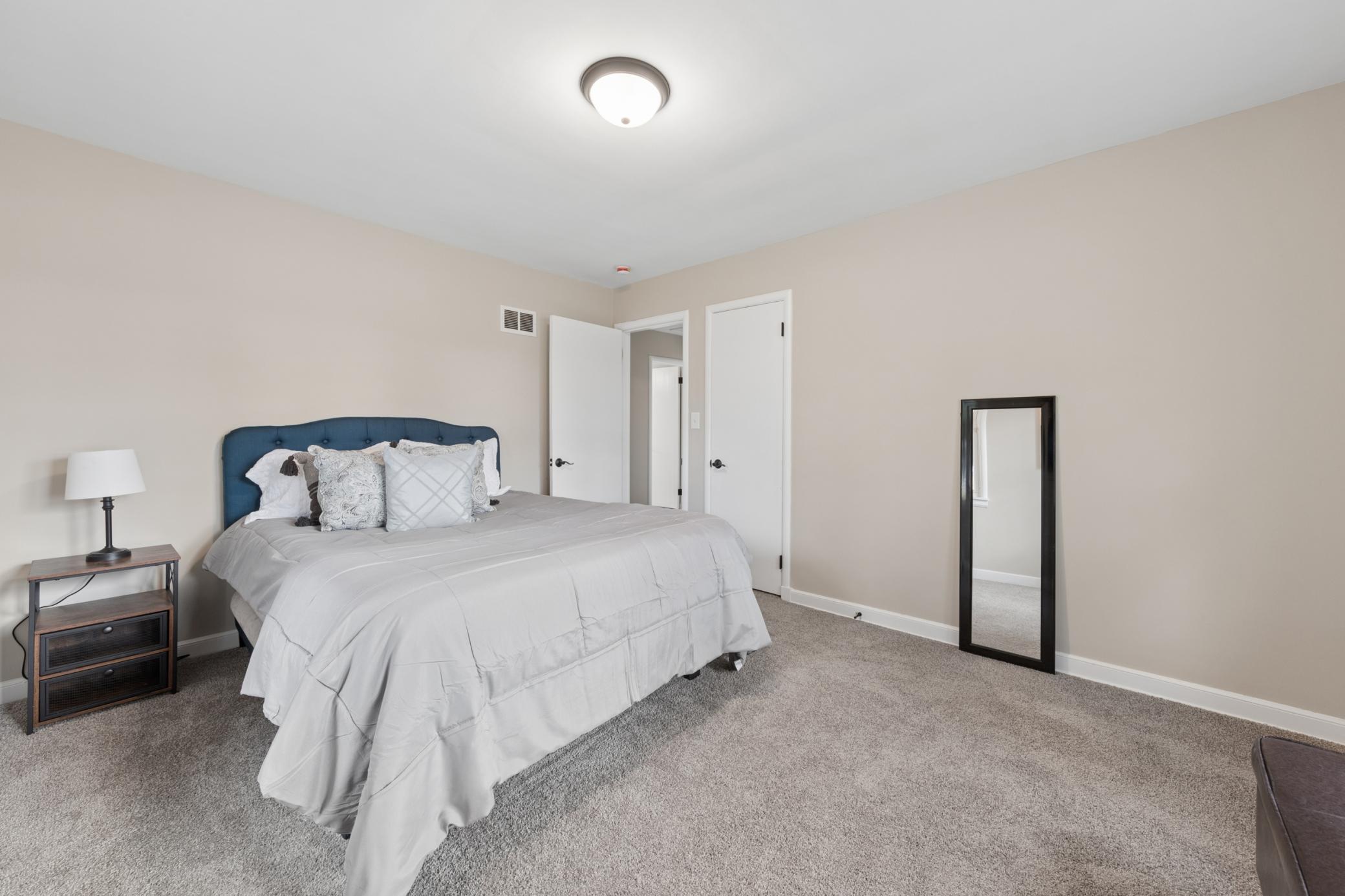 Comfortable primary bedroom with plush carpeting, neutral décor, and plenty of natural light.