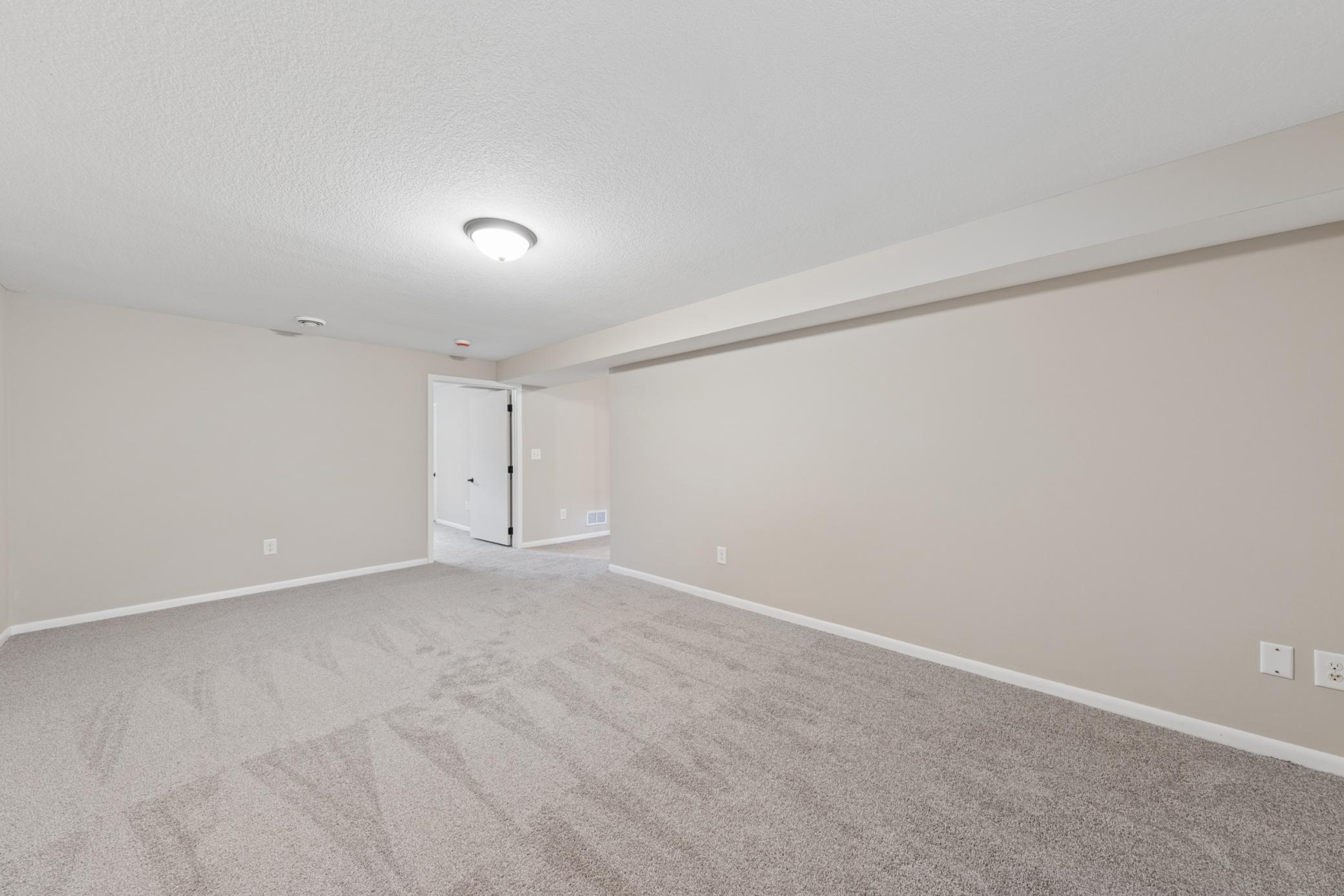 Expansive lower-level family room offering flexible space for recreation, media, or home office use.