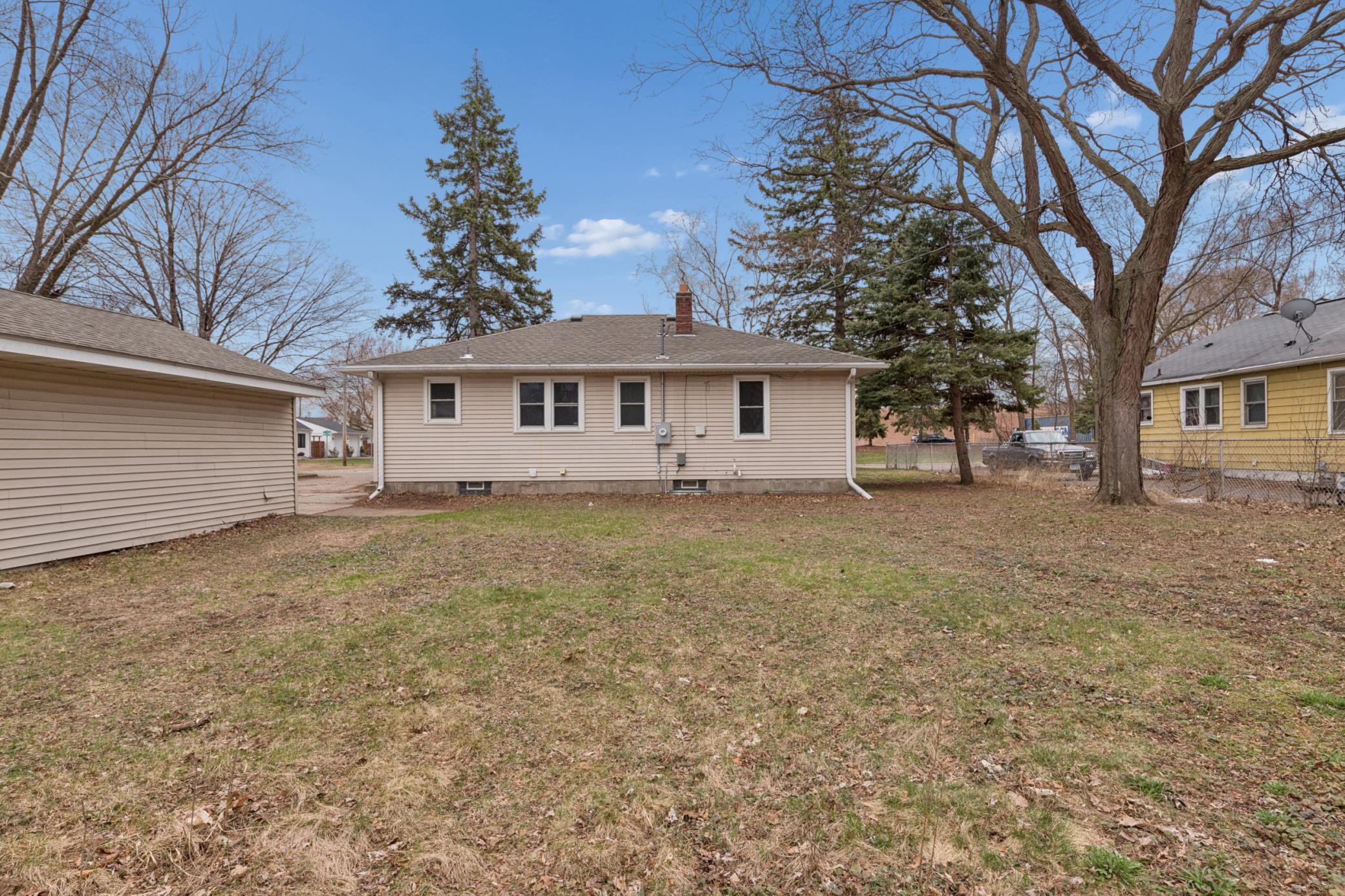 Rear exterior featuring maintenance-free siding, private back entry, and easy access to the yard and driveway.