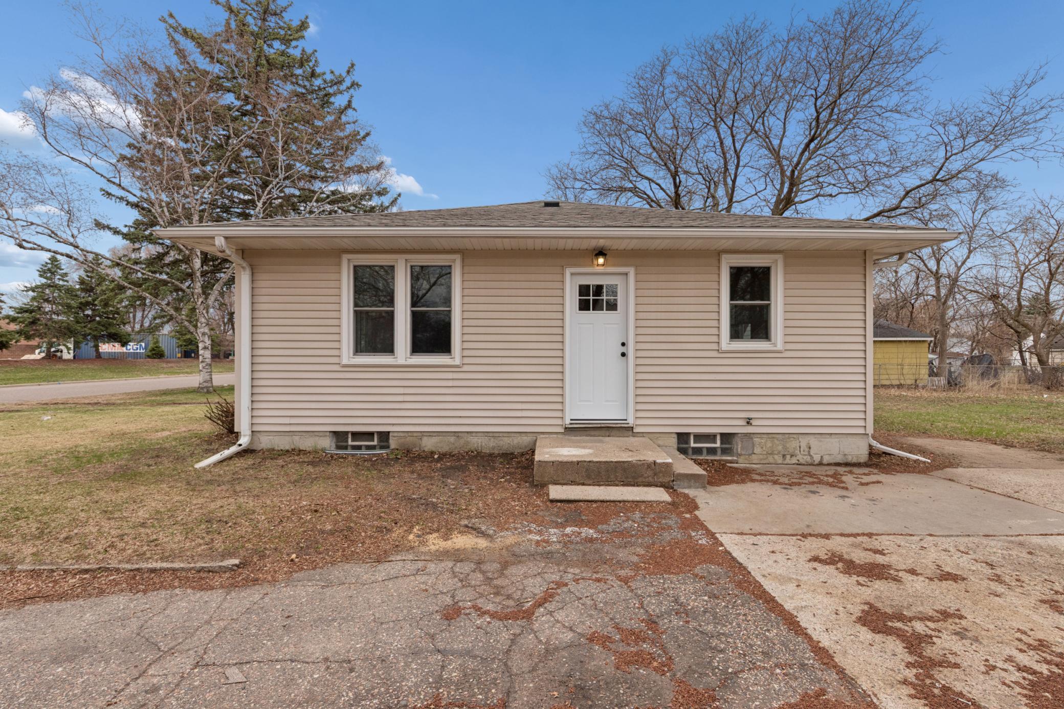 Side exterior view showcasing detached garage, extended driveway, and generous lot size.