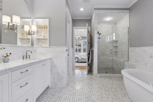 Primary bathroom features separate tub and walk-in shower, Carrara Italian marble, heated floors, and double sinks.
