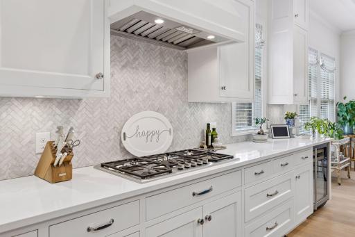 Gas stovetop and herringbone tile backsplash
