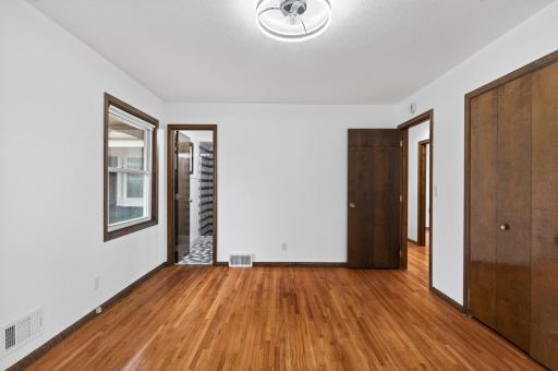 Primary bedroom with double closets, windows on two walls and 3/4 bath.