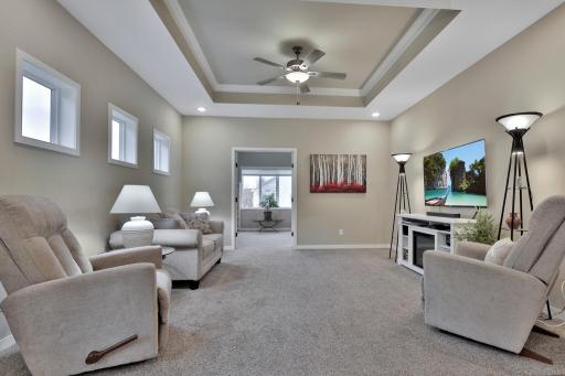 Living room with recessed ceiling feature and fan