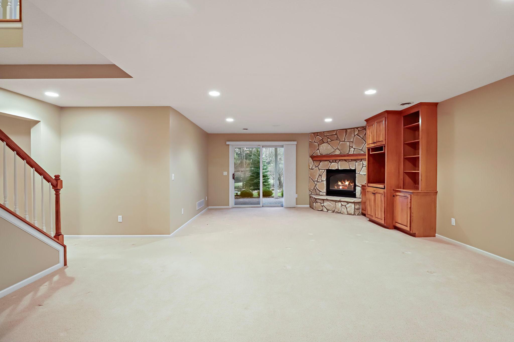 Walkout family room with built-ins and a stone gas fireplace.