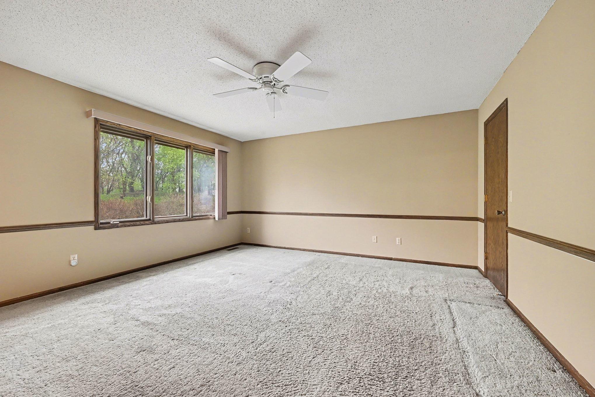 Primary bedroom w/ windows overlooking the backyard
