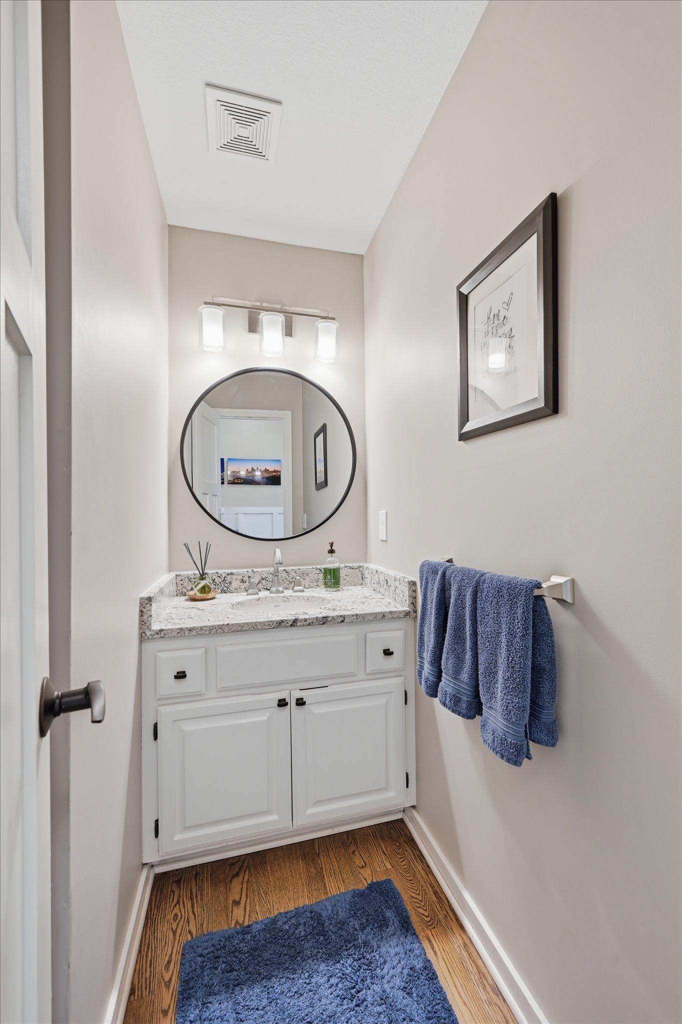 Main floor half bath with granite countertop that matches the kitchen.