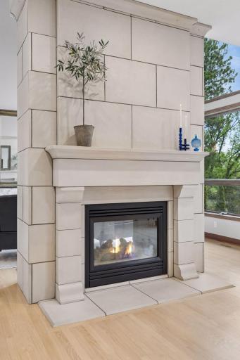 A striking see-through fireplace brings warmth and ambiance to both the kitchen and great room, elevating everyday living with a touch of luxury.