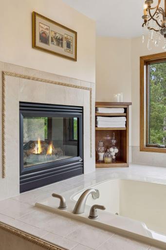 The primary suite features a stunning see-through fireplace, adding warmth and ambiance.