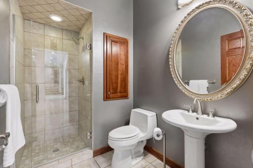 An elegantly appointed main-level 3/4 bath offers a refined retreat for guests with upscale finishes and timeless design.