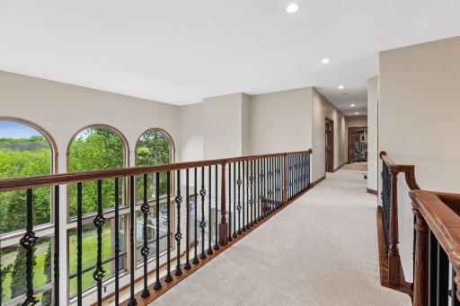 The dramatic upper-level catwalk overlooks both the grand entry and soaring great room.