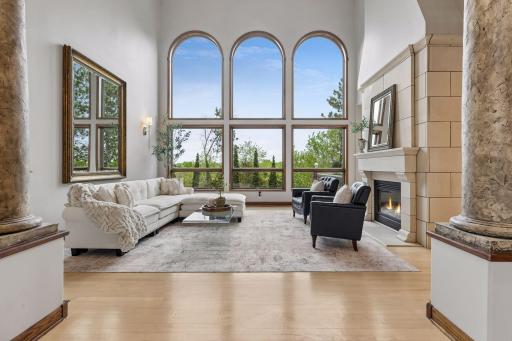 A breathtaking great room with soaring ceilings, walls of windows, and an abundance of natural light creating an unmatched sense of warmth and grandeur.