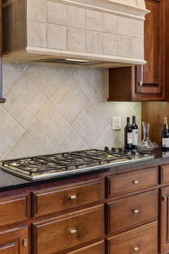 A stunning Thermador range and statement hood vent anchor the kitchen with professional-grade performance and striking designer style.