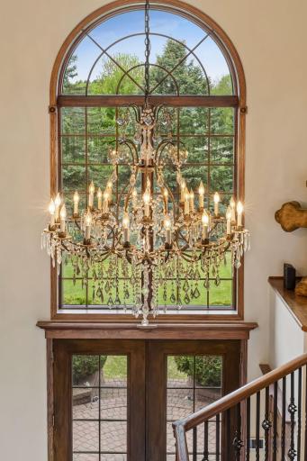 A statement chandelier adds dramatic elegance and timeless luxury to the homeâs stunning architectural design.