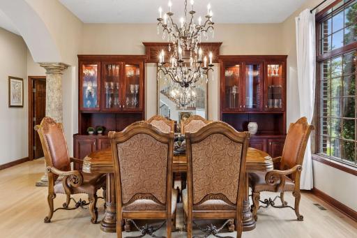 The elegant formal dining space impresses with its curved entry and statement chandelier.