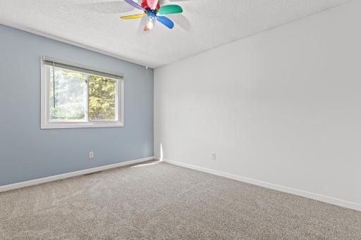 First upper level bedroom has abundant natural light, fresh paint, and plush carpeting.