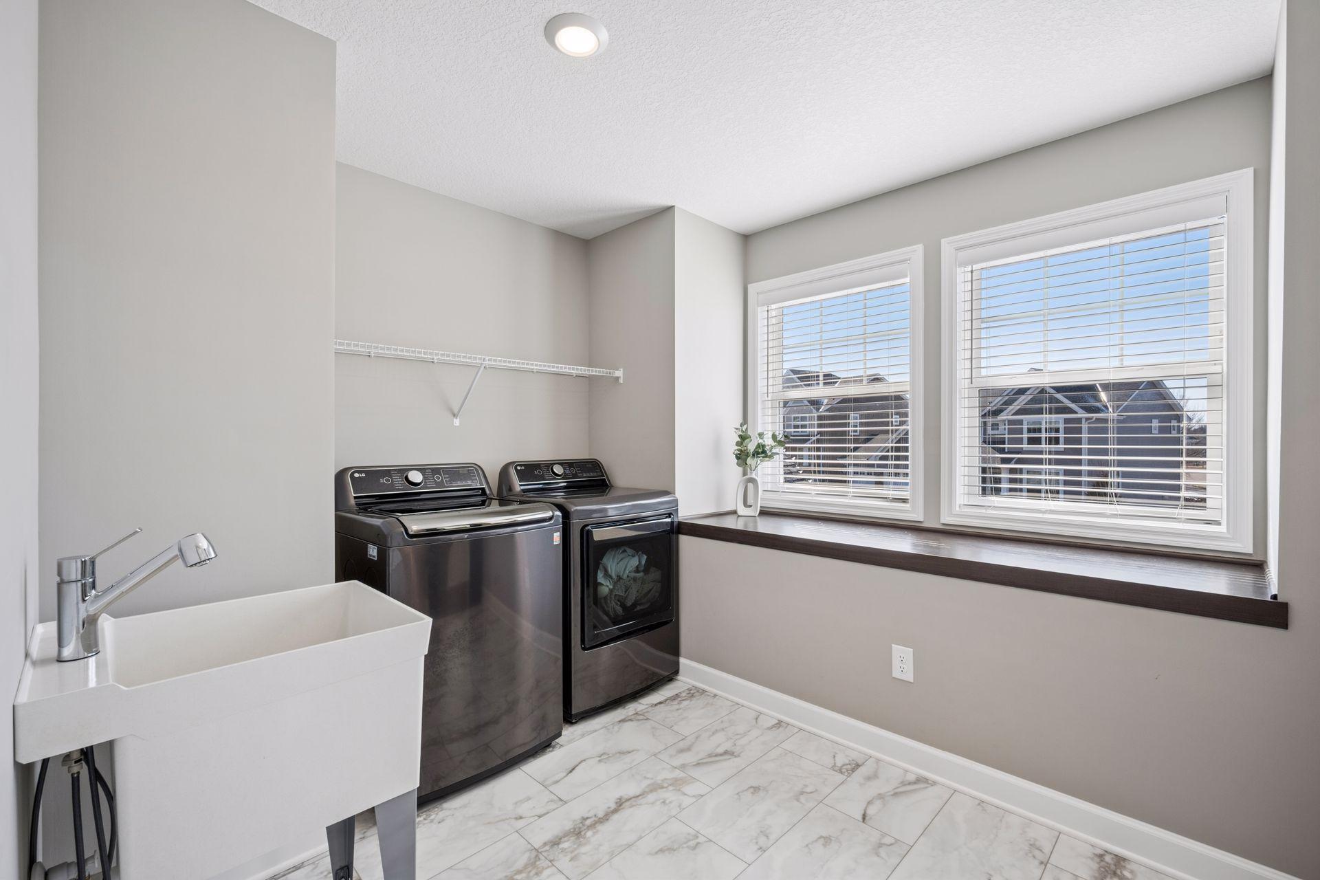 Large upstairs laundry room with sink and folding area