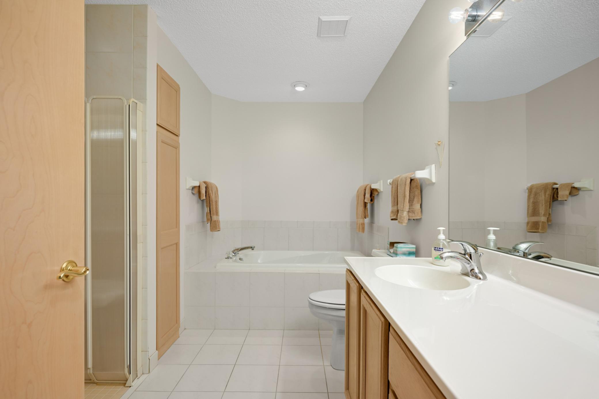 A full primary bath with a large vanity and a separate tub and no step shower.