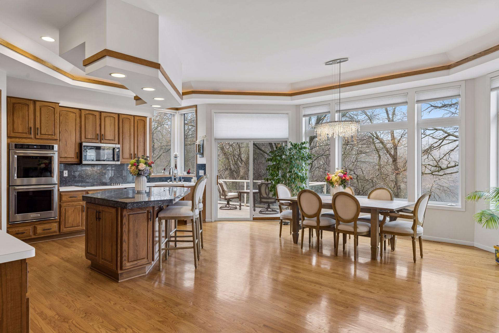 This beautifully designed kitchen and dining space offers the perfect blend of functionality and scenic views. Rich wood cabinetry, granite countertops, and a center island with seating.
