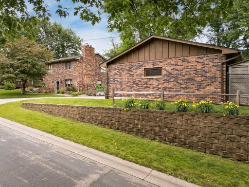 Street view of the home and garage showing off some of the wonderful landscaping. Storage shed behind the garage for extra storage needs.