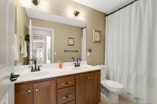 Full-sized upper-level bathroom featuring dual sinks and beautiful cabinetry for added storage and convenience.