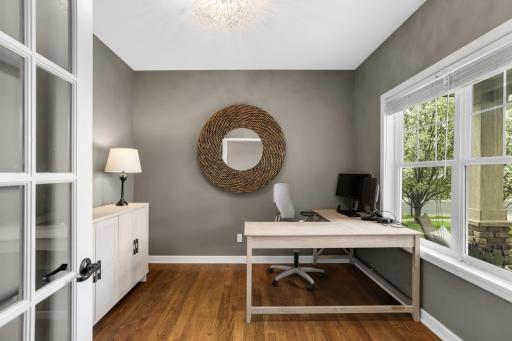 Front-facing private office with large windows that bring in natural light while still offering a quiet, comfortable space away from the main living areas.