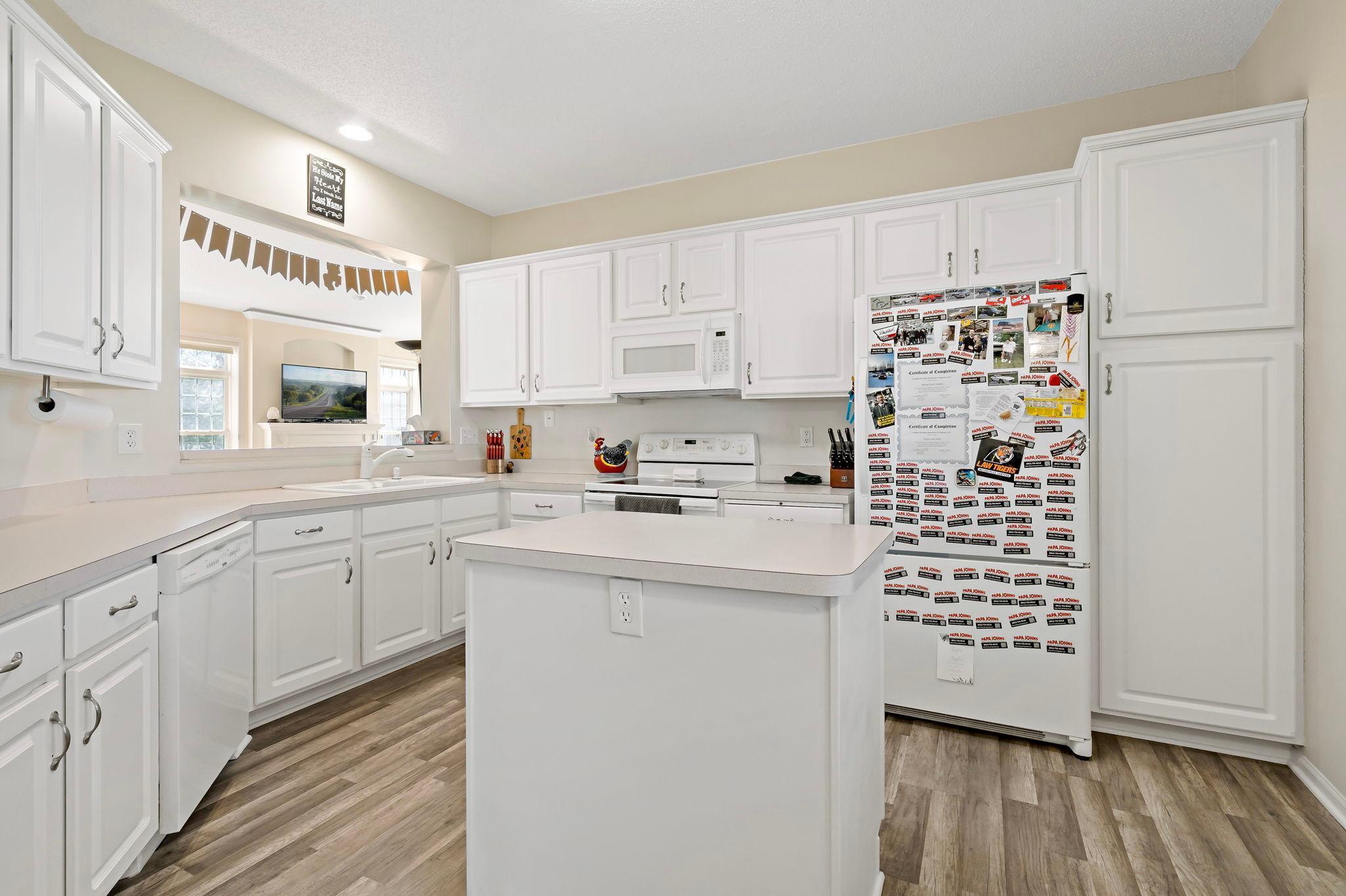 Bright white kitchen flows seamless into dinning and living room