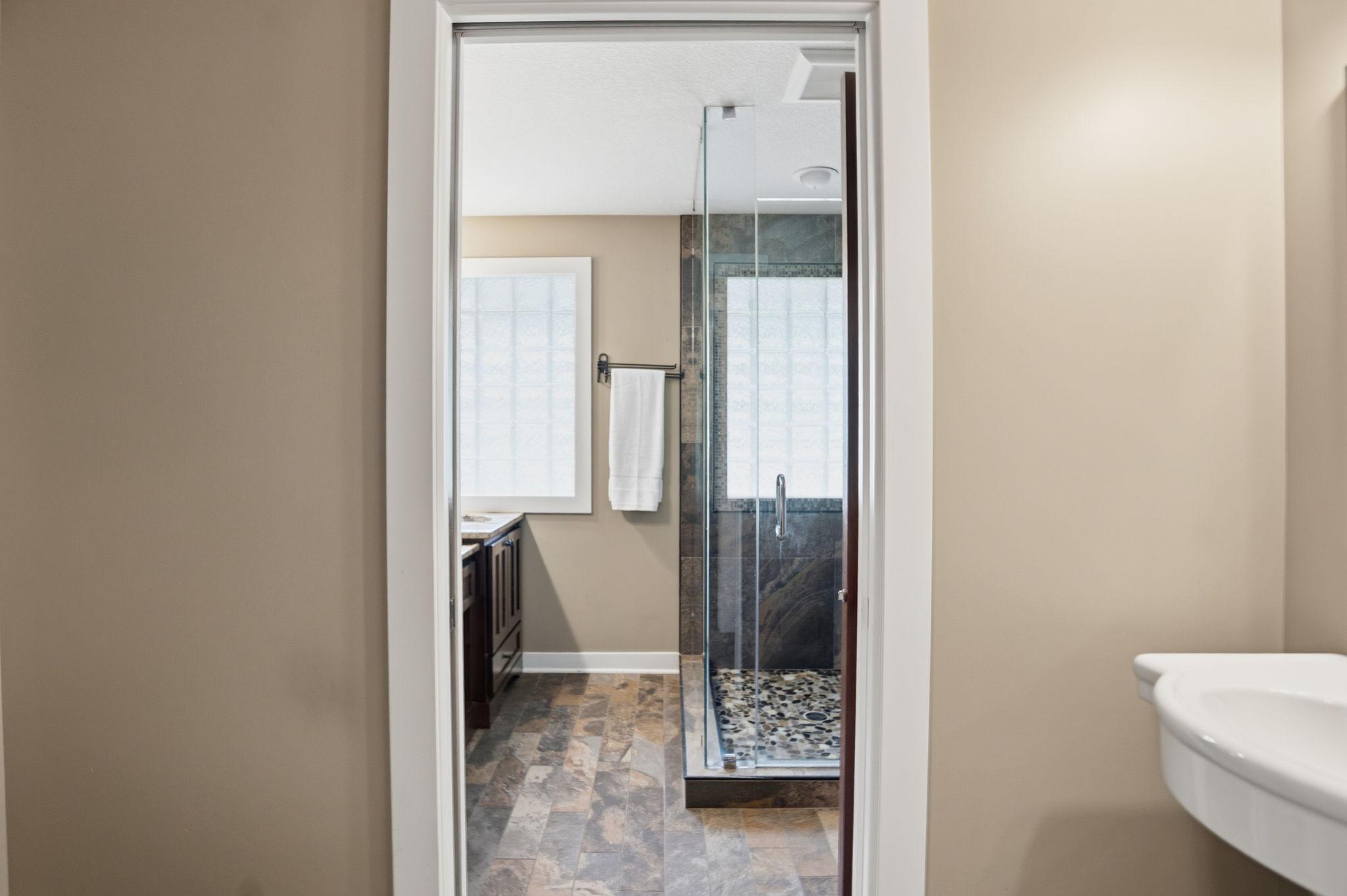 view from hallway of powder room & primary bath