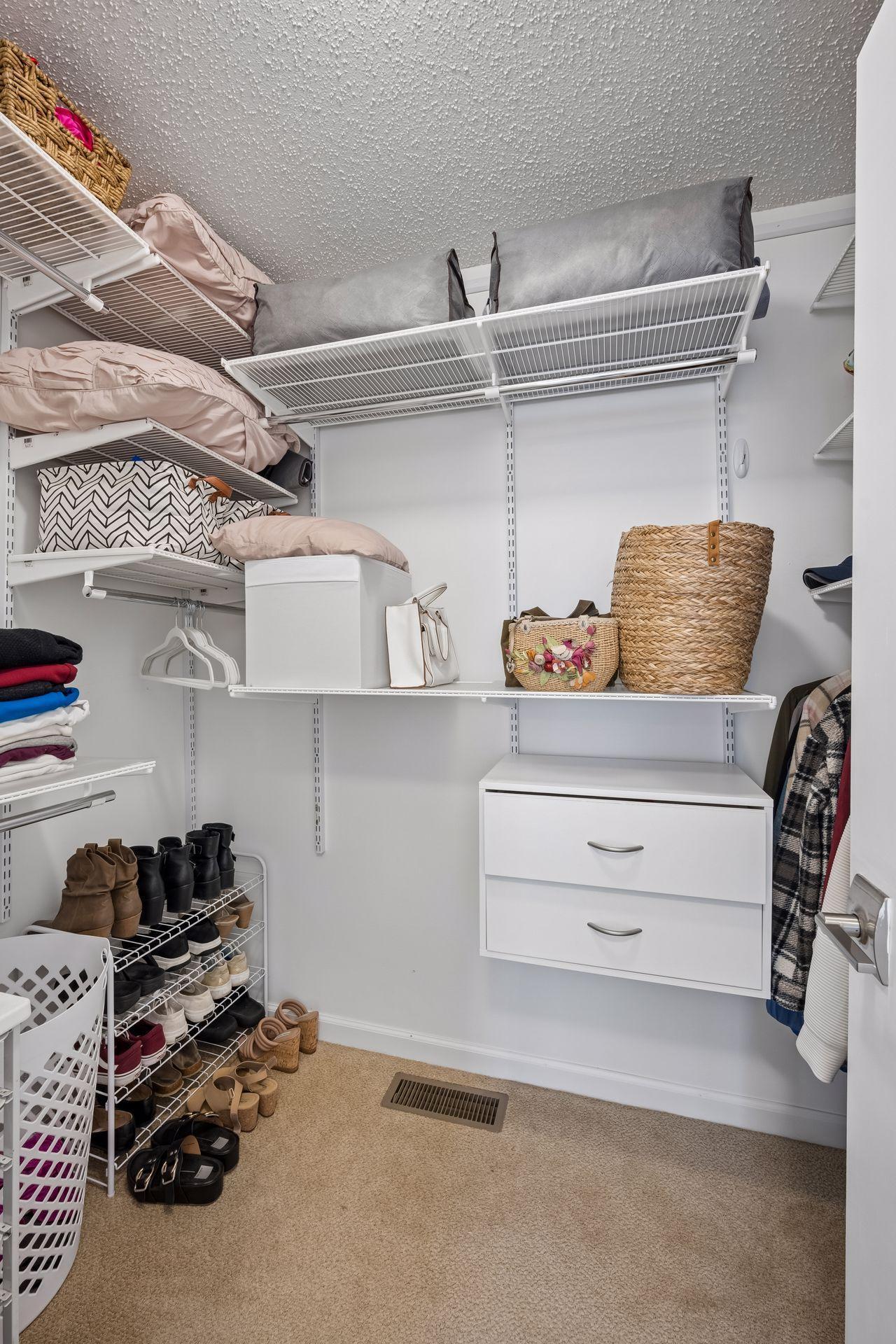 Walk in primary closet with custom closet organizers