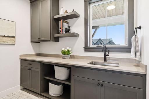 Large laundry space includes a sink and plenty of storage