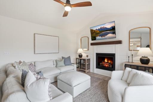 Vaulted great room with updated mantle and custom wall moulding accents surrounding the fireplace.