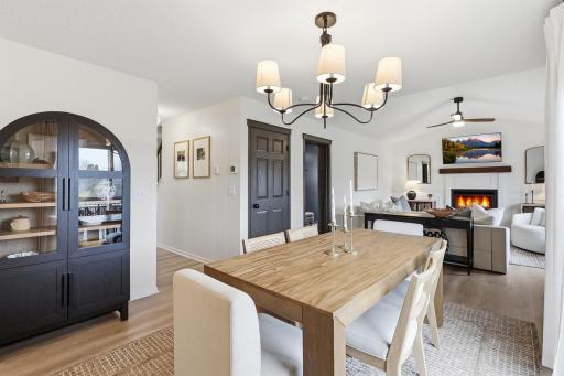 Open concept dining space connected to the living room with updated light fixture and seating for 6.