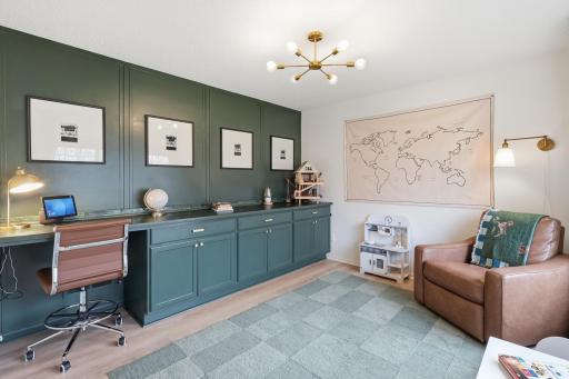 Front flex room with custom built-ins, desk area, and accent wallâperfect for a home office, sitting room, or playroom.