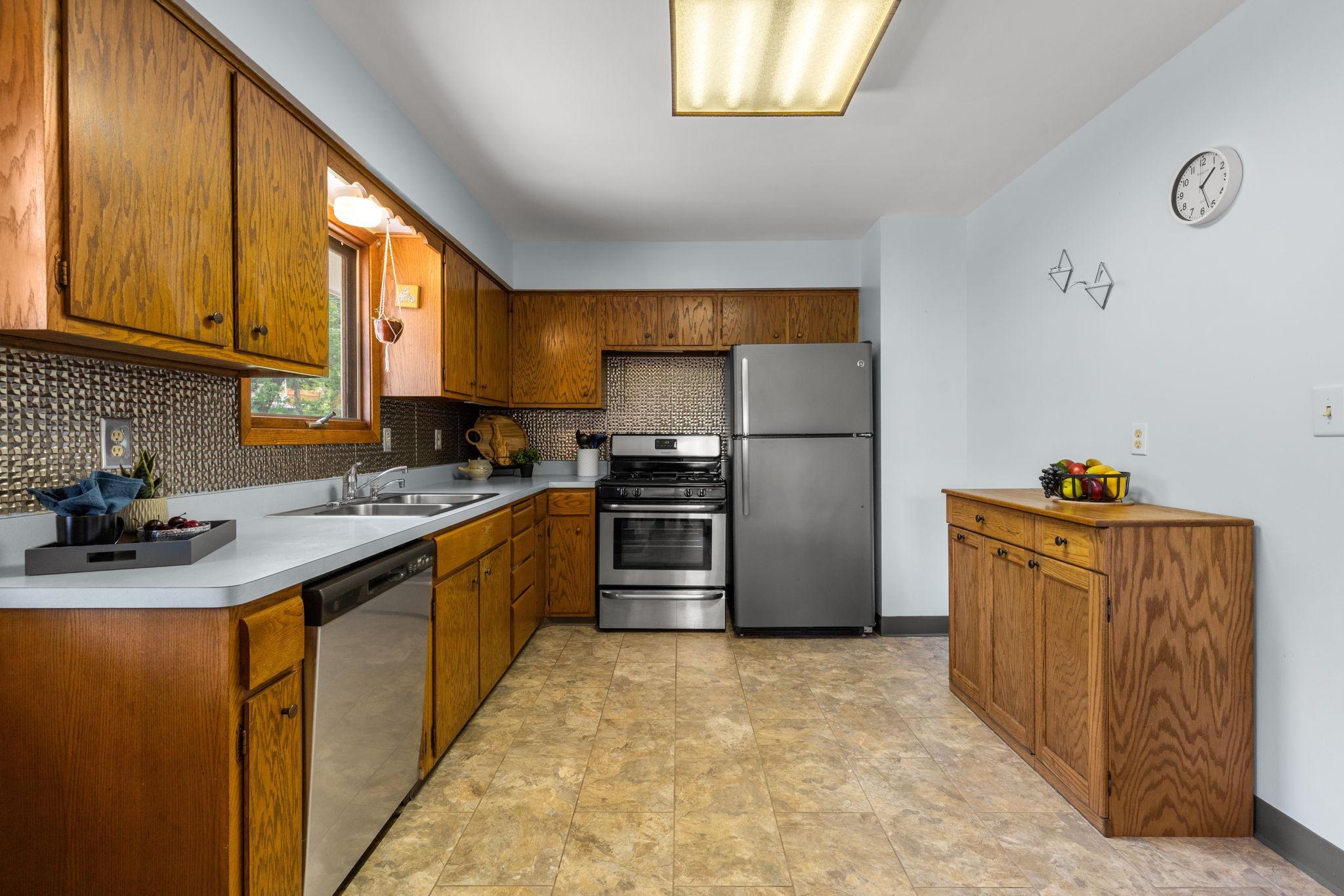 Spacious kitchen features newer flooring, backsplash and SS appliances.