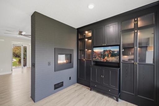 A dark palette, custom built-ins, and a double-sided gas fireplace come together to create an intimate retreat that invites you to slow down, pour a drink, and stay a while.
