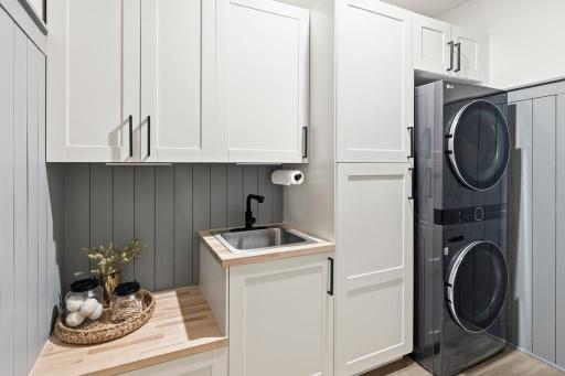 Who says laundry rooms can't be beautiful? Board and batten wall treatment, roll-out shelving, a laundry sink, a drop zone, and abundant storage make this one of the most functional â and surprisingly stylish â spaces in the home.