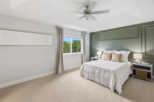 The primary suite is a true sanctuary â bright, spacious, and thoughtfully designed from top to bottom. A tray vault ceiling and wainscoting bring an elevated, custom feel to the bedroom.
