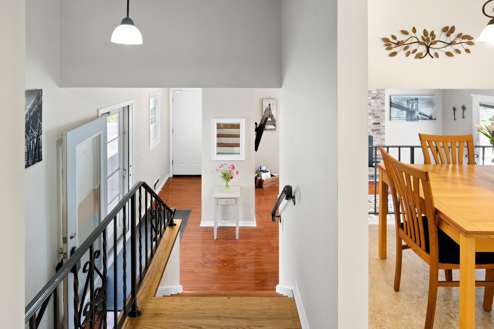 Spacious front entry with laminate flooring, wrought iron railing and fresh neutral paint!