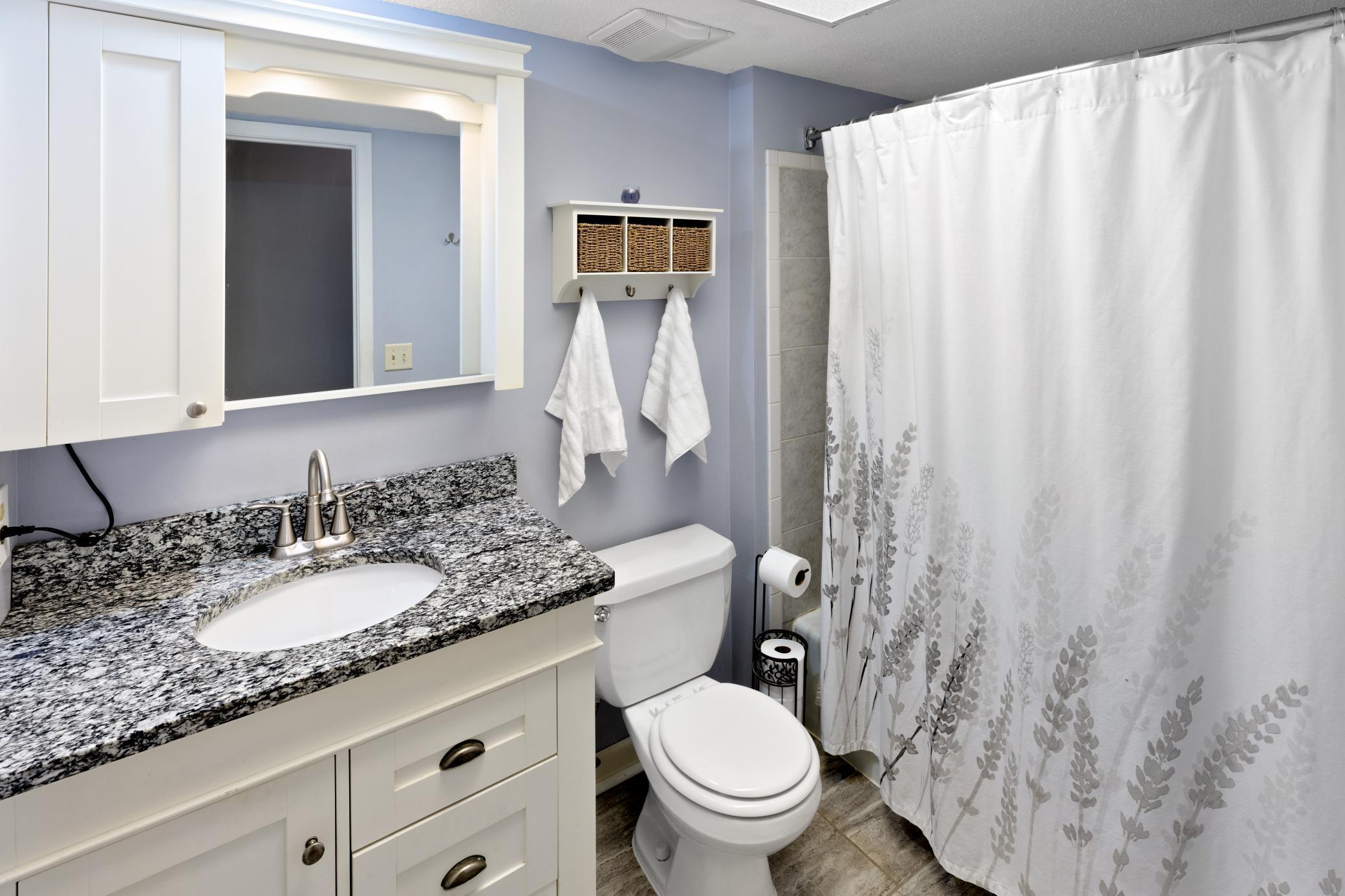 Updated full bathroom on Upper Level has updated vanity, ceramic flooring, granite countertop and decorative mirror.