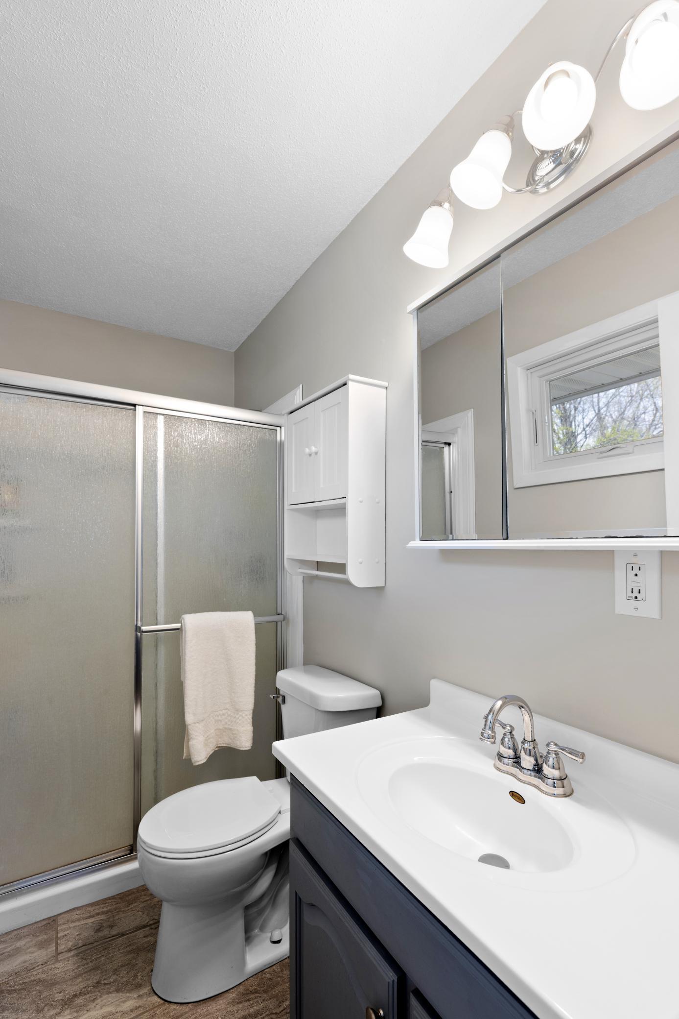 Private Owner's Bath has ceramic flooring, updated vanity, mirror and lighting!