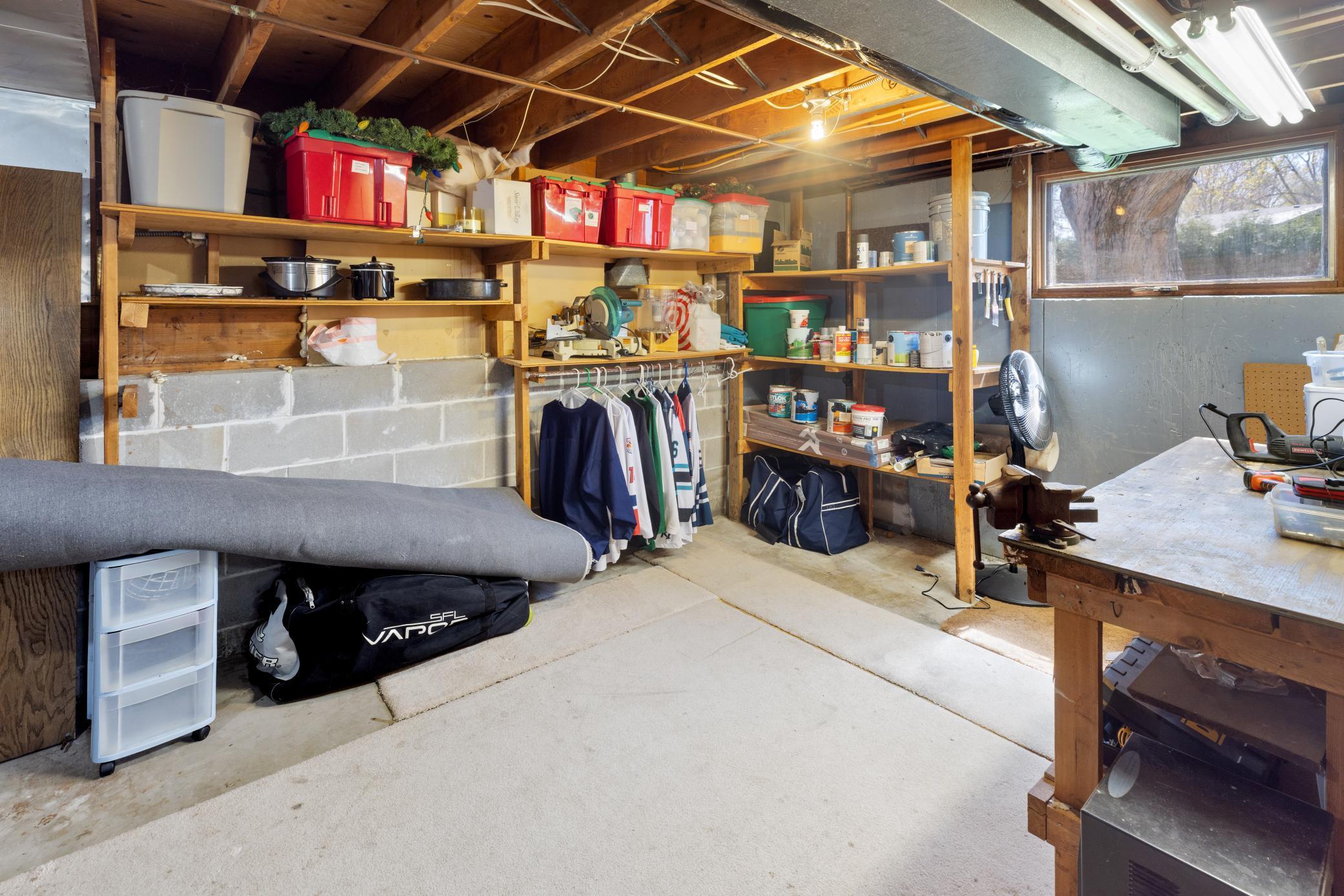 There is a huge storage room that has a workbench, peg board and built-in storage shelving.