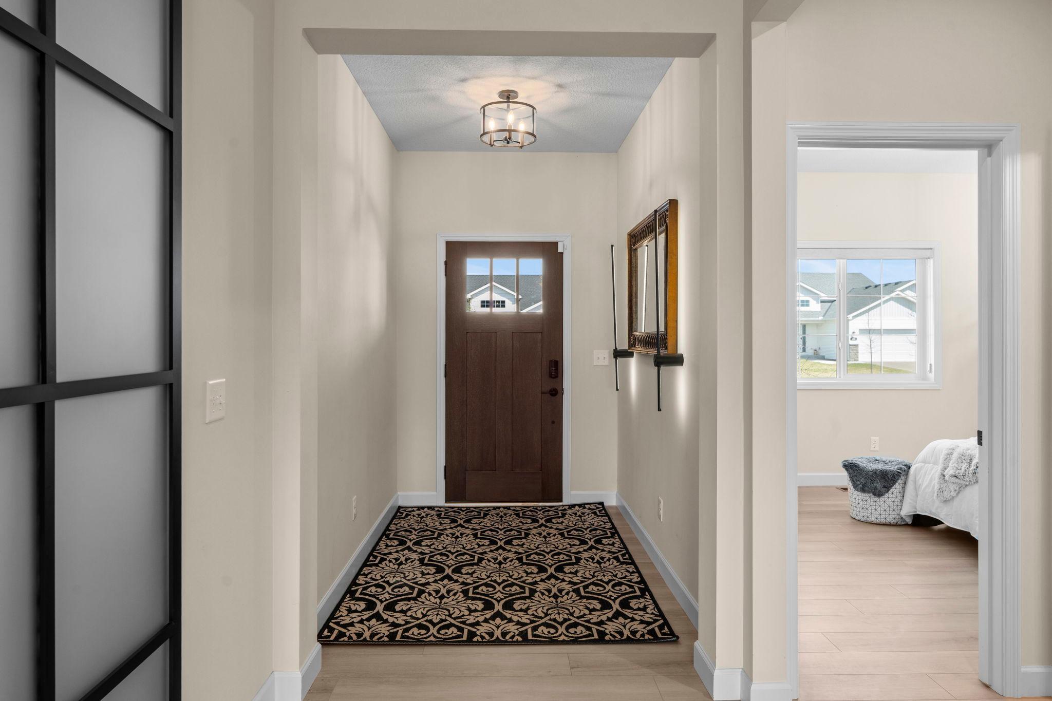 Spacious foyer with sconce lighting around mirror